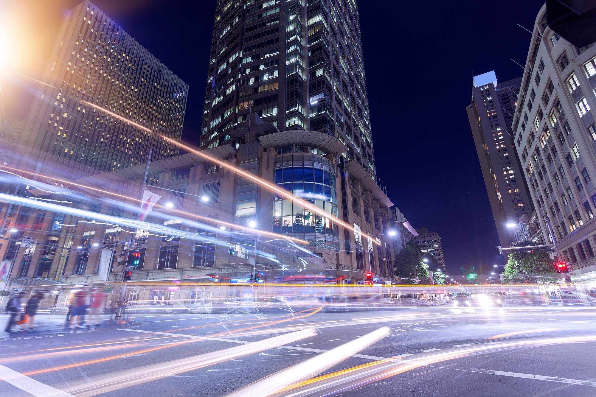 Sydney CBD intersection at night with light trails from traffic